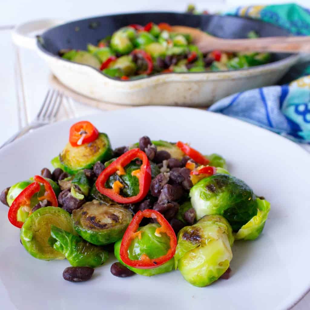 This plant-based main dish or side features Brussels Sprouts, Chili Peppers, and Black Beans. Found on The Grateful Grazer.