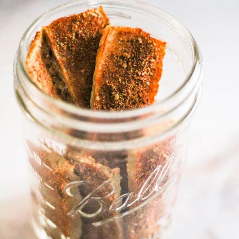 Spicy dried tofu jerky in a glass jar.