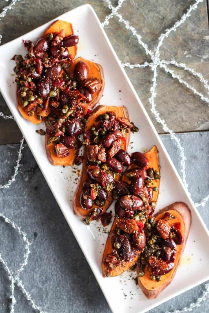 Sweet potato toast topped with a savory tapenade of olives, capers, garlic, and fresh herbs. Healthy holiday party appetizer! Vegan, Gluten-Free.