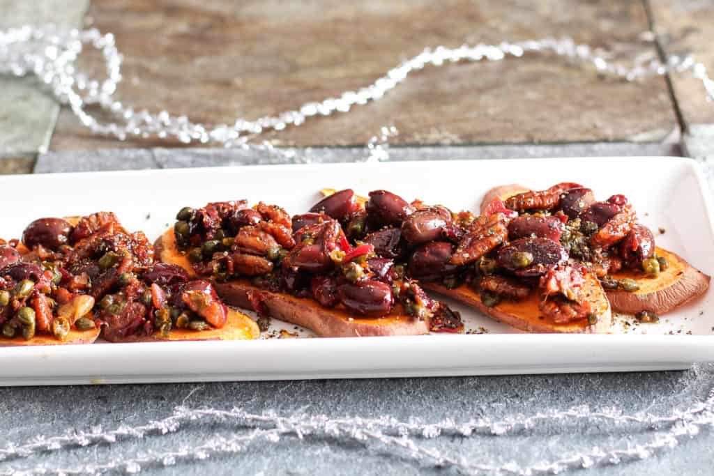 Sweet potato toast topped with a savory tapenade of olives, capers, garlic, and fresh herbs. Healthy holiday party appetizer! Vegan, Gluten-Free.