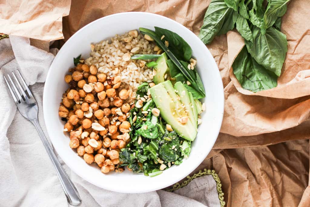 Chickpea bowls served with spicy peanut sauce and seasonal sesame oil greens for the delicious flavors of Thai take-out from home. Easy plant-based recipe!