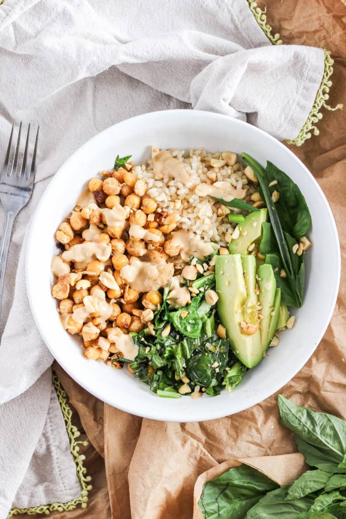 Chickpea bowls served with spicy peanut sauce and seasonal sesame oil greens for the delicious flavors of Thai take-out from home. Easy plant-based recipe!