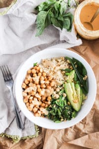 Chickpea bowls served with spicy peanut sauce and seasonal sesame oil greens for the delicious flavors of Thai take-out from home. Easy plant-based recipe!