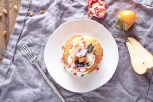 Pumpkin Oat Pancakes with Fruit & Yogurt Topping - a delicious breakfast or brunch dish for fall. This plant-based recipe is a crowd-pleaser!