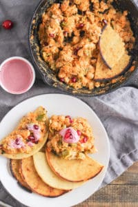 This fall-inspired chickpea scramble is the best way to use leftover roasted veggies and cranberry sauce from your Thanksgiving dinner. Serve the scramble on a piece of homemade socca flatbread for a festive start to the holiday season!