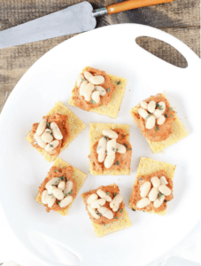 Cannellini Bean Polenta Squares are a festive (and completely vegan) appetizer for the holidays and beyond. Guests will love this delicious bite of polenta (Italian grits) smothered in roasted red pepper and sun-dried tomato bean and walnut spread.