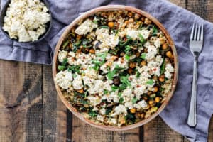 Comforting and delicious Greek roasted chickpeas served with vegan tofu feta, spicy greens, and freekeh. You need this dinner in your weeknight rotation!