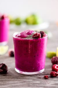 Hot pink dragon fruit smoothie with berries and lime.