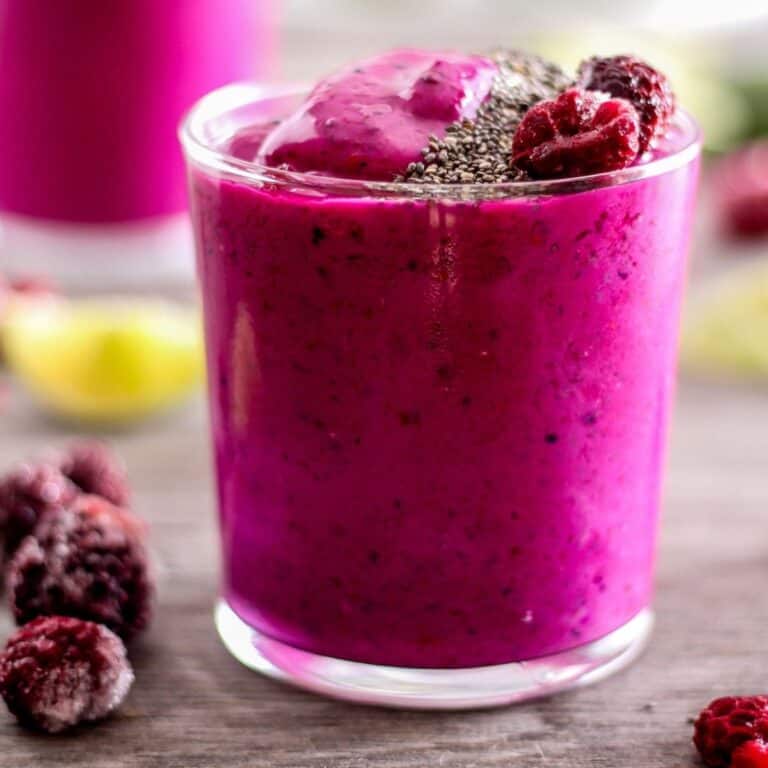 Vibrant pink dragon fruit smoothie with berries and chia seeds.