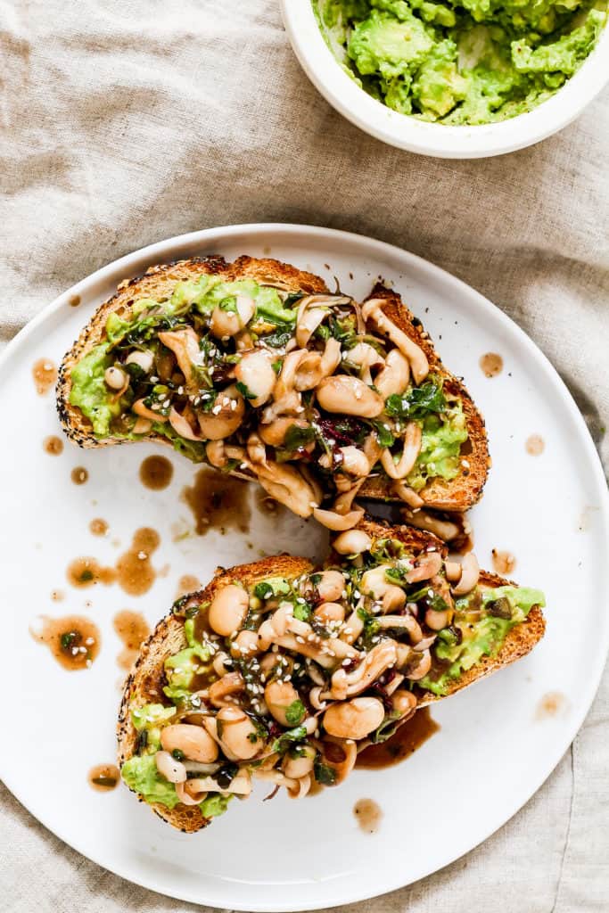 Mushroom avocado toast. A delicious recipe for savory breakfast lovers who don't like eggs. Topped with white beans for extra plant-based protein!