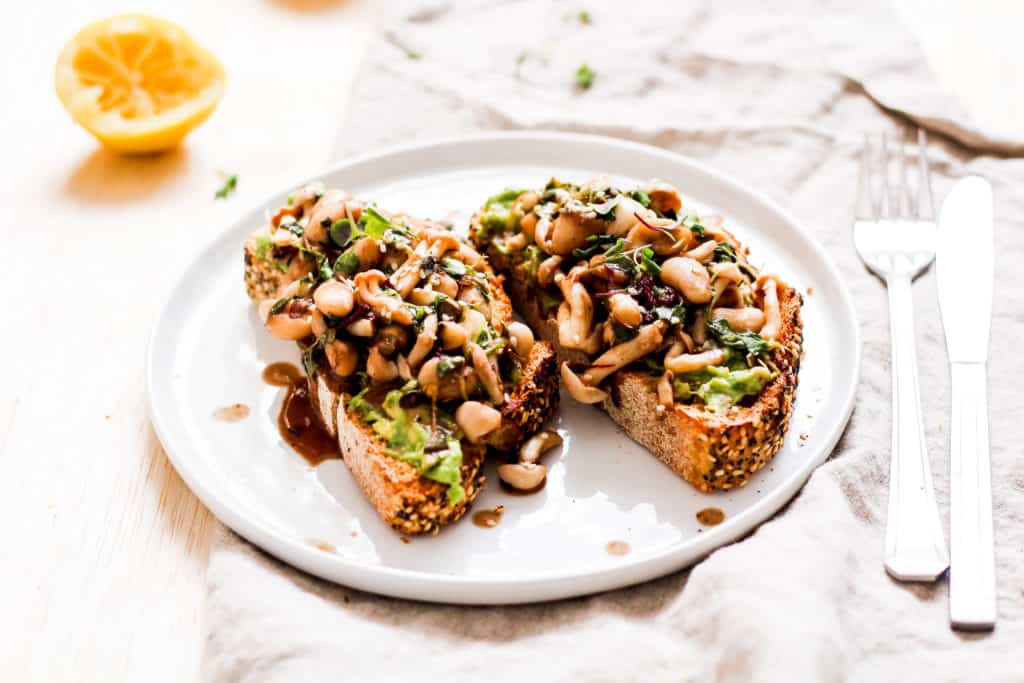 Mushroom avocado toast. A delicious recipe for savory breakfast lovers who don't like eggs. Topped with white beans for extra plant-based protein!