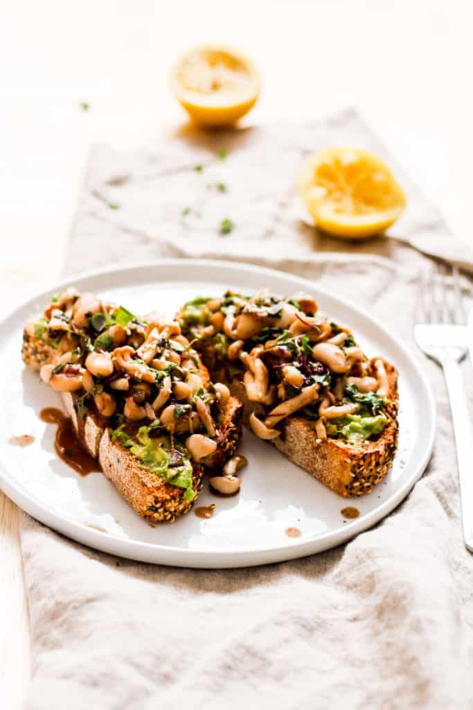 Mushroom avocado toast. A delicious recipe for savory breakfast lovers who don't like eggs. Topped with white beans for extra plant-based protein!