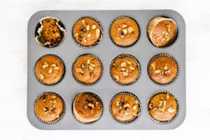 Overhead shot of gluten-free golden milk muffins in a muffin tin against white backdrop.