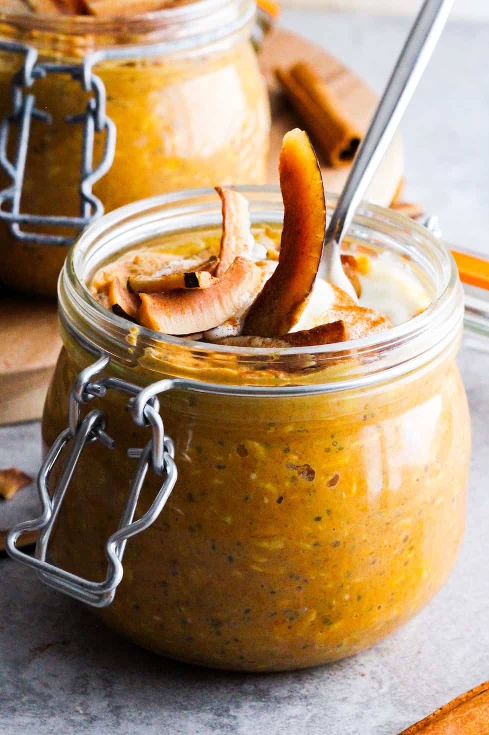 Coconut Cream Pumpkin Overnight Oats in mason jar with toasted coconut slices on top. Straight-on view.