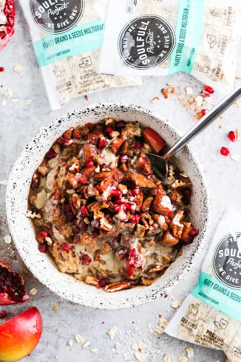 Cinnamon apple tahini oatmeal bowl with packets of The Soulfull Project cereals.