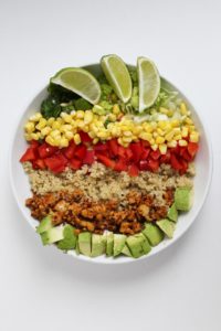 Bowl recipes. Colorful tempeh taco bowl in white bowl against white background.