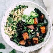 Savory oatmeal bowl topped with black beans, sweet potato, and yogurt.