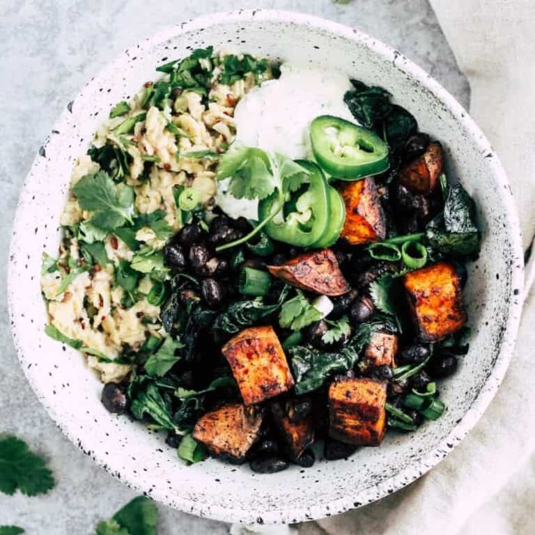 Savory oatmeal bowl topped with black beans, sweet potato, and yogurt.