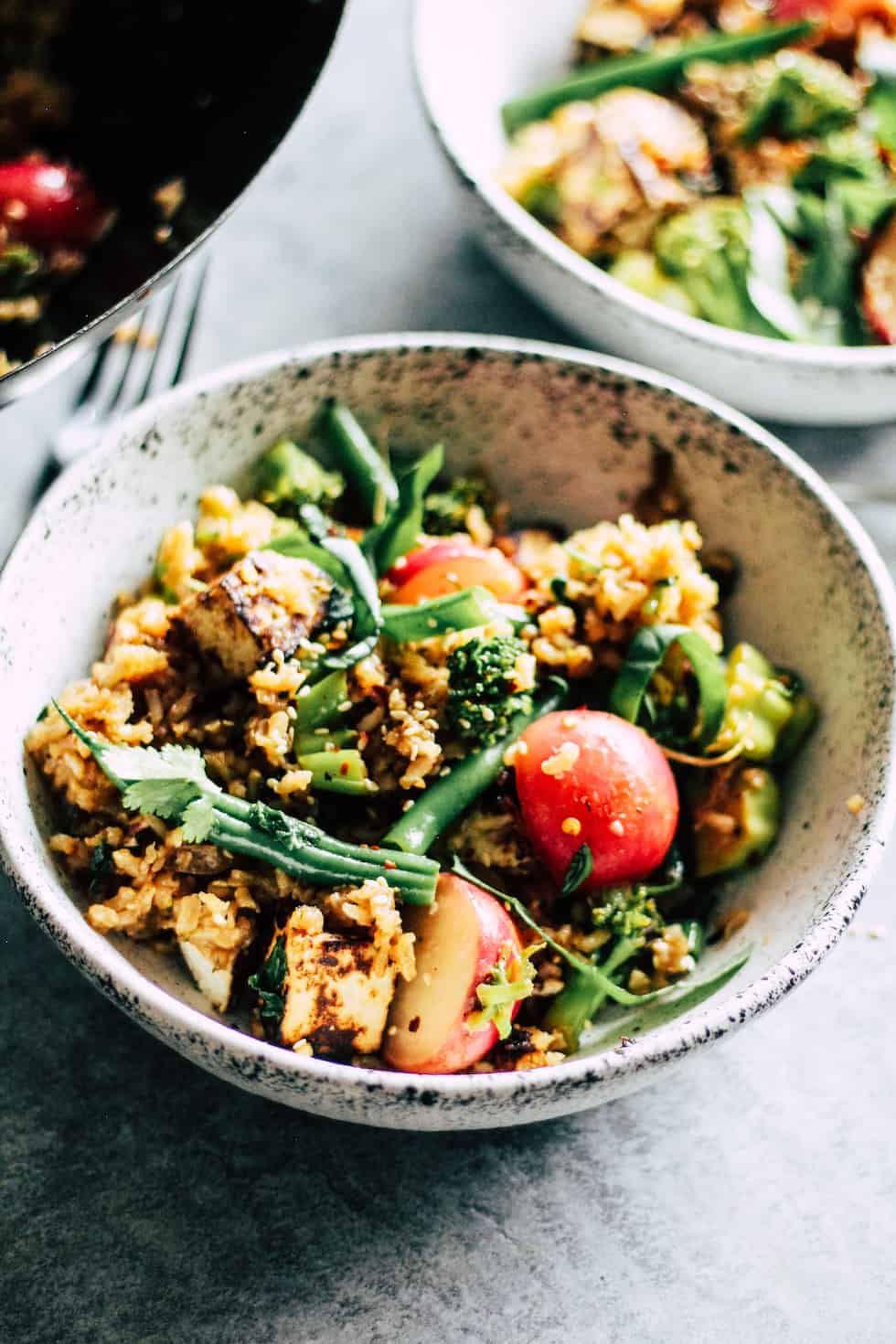 Veggie fried rice in white stone bowl with radishes and green beans.