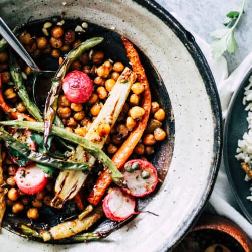 Chickpeas, carrots, and radishes in a stone bowl with rice.