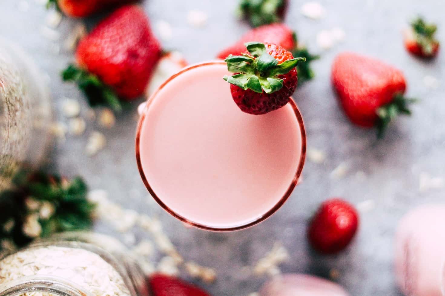 Overhead shot of strawberries and glass of homemade strawberry milk.