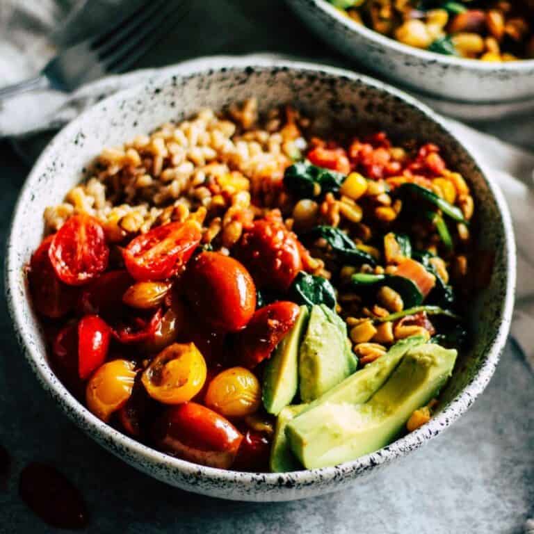 Vegetarian tempeh burrito bowl with avocado and cherry tomatoes.