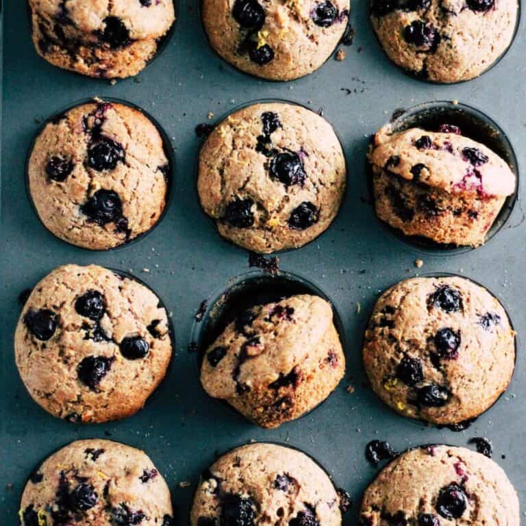Whole wheat blueberry muffins with lemon and flax in a muffin tin.