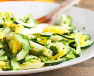Mango Cucumber Salad on white platter is a recipe featured in this summer produce guide.
