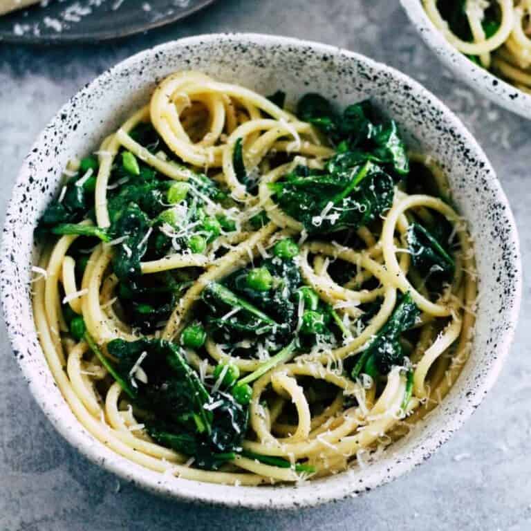 Cacio e pepe pasta with spinach and green peas.