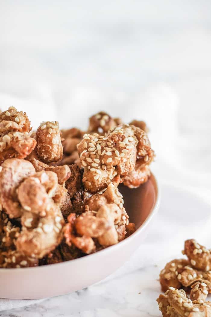 Nut clusters in a bowl against white background.