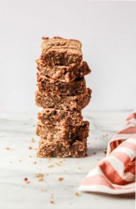 Plant-based snack ideas including vegan protein bars stacked on white counter.
