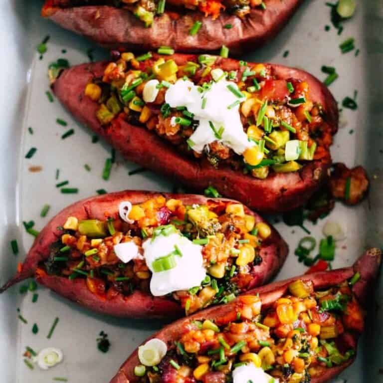Loaded sweet potatoes with vegan BBQ tempeh and toppings.