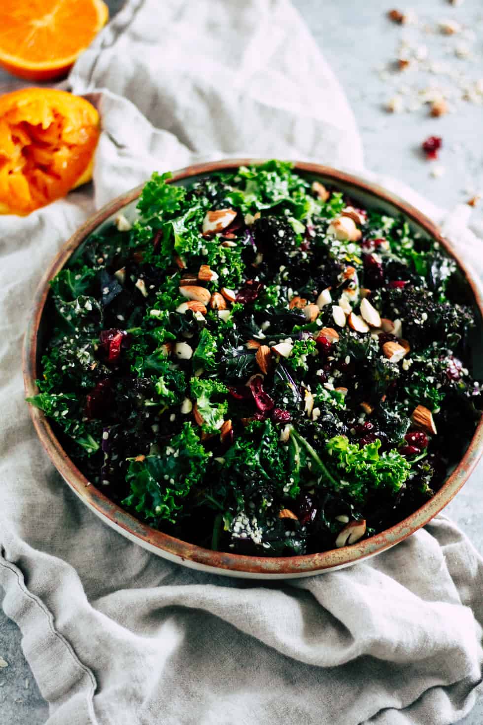 Make-ahead kale salad in ceramic dish with cream napkin.