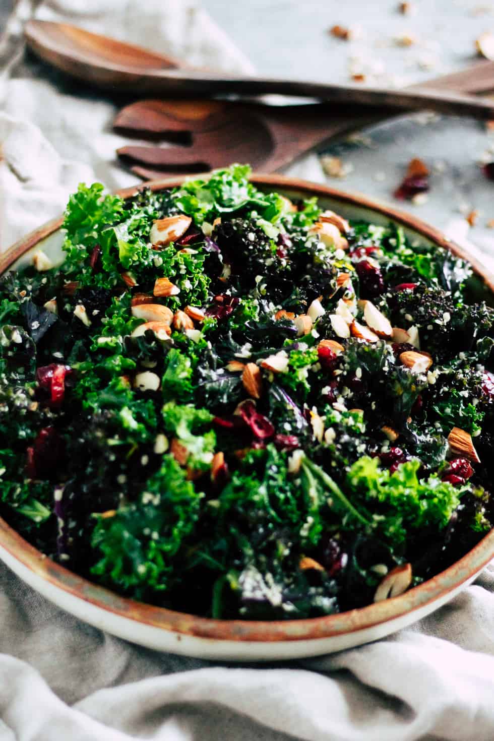 Make-ahead kale salad in ceramic dish with cream napkin.