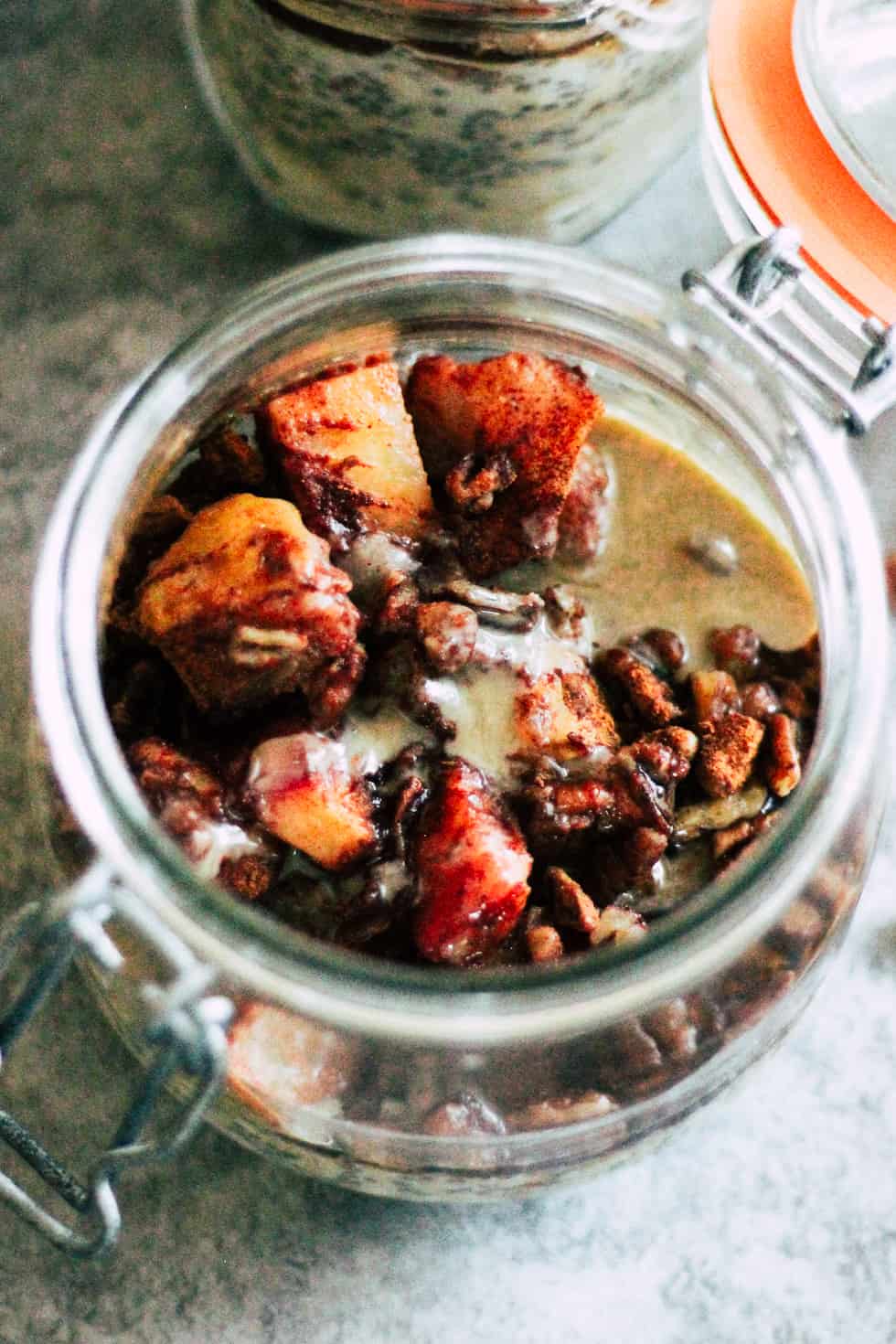 Open mason jar of overnight oats against grey background.