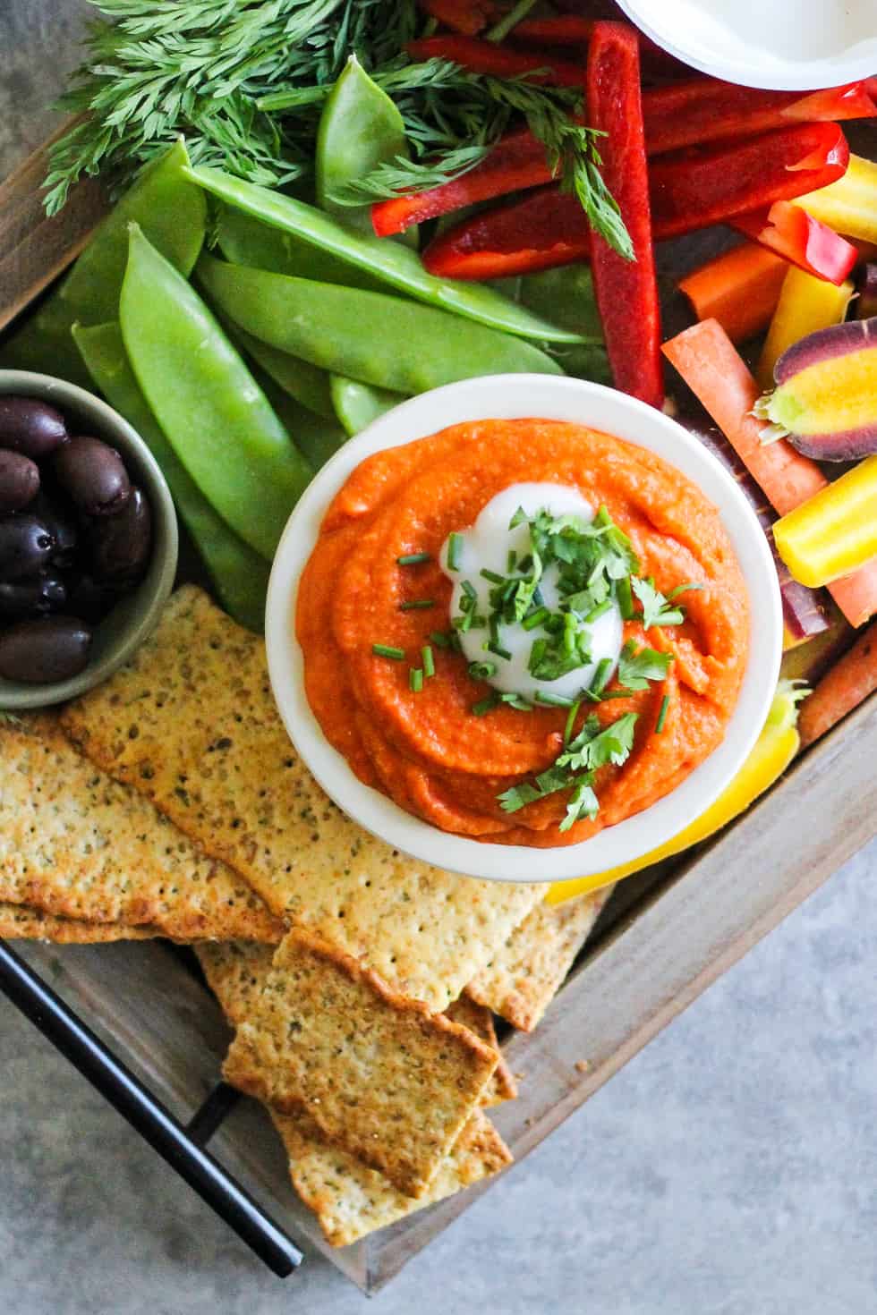 Party board with orange dip and vegetables.