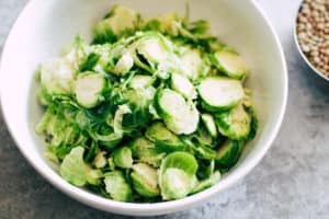 Sliced brussels sprouts in white bowl.