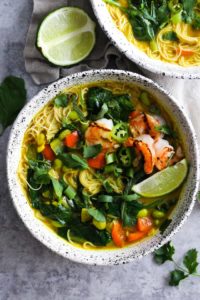 Coconut Noodle Soup with lime in white bowls.