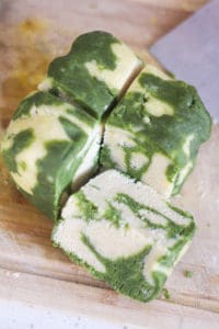 Marbled matcha sugar cookie dough cut into four pieces.