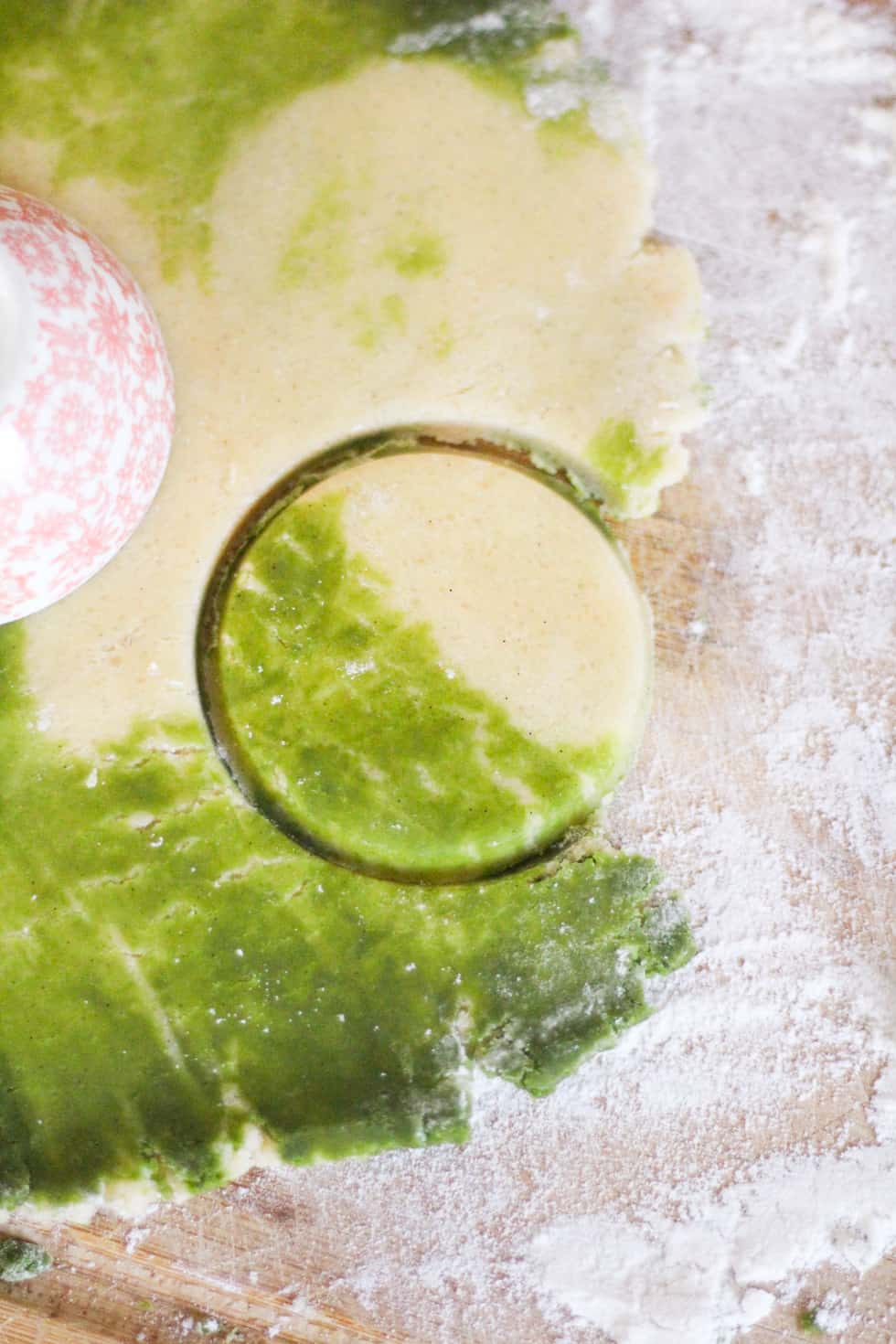 Green and white cookie dough cut into round circle.