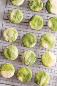Marbled green and white cookies on wire rack.
