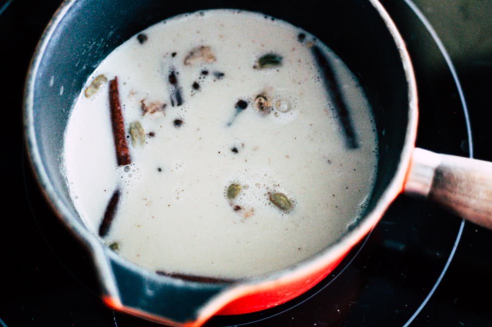 Infusing spiced oat milk in a saucepan.