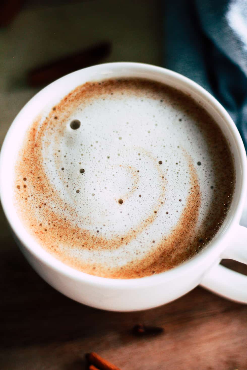 Dairy-free spiced oat milk latte on wood tray.