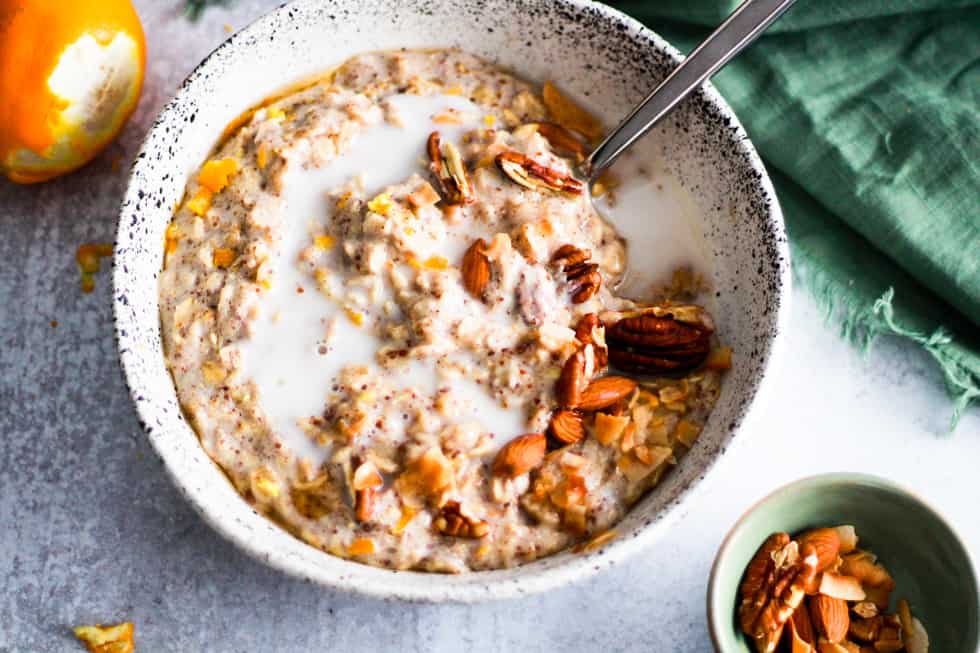 Horizontal image of vegan lemon oatmeal in a white bowl with almond milk. 