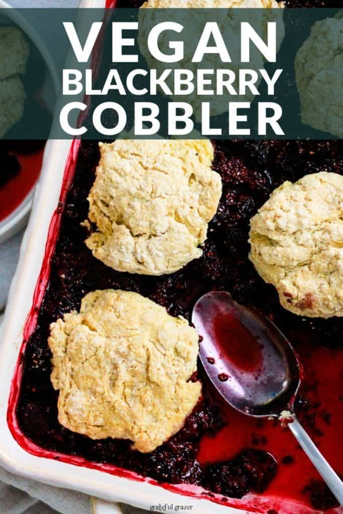 Berry cobbler in white baking dish with text that reads, "Vegan Blackberry Cobbler."