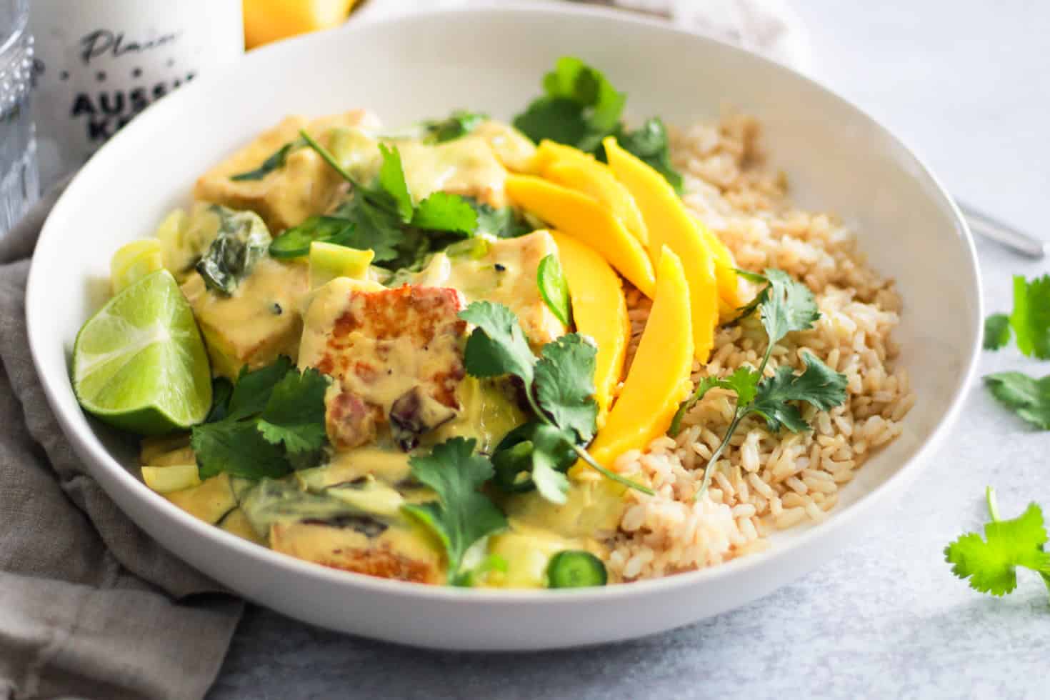 Bowl of rice and mango with tofu and fresh cilantro. 