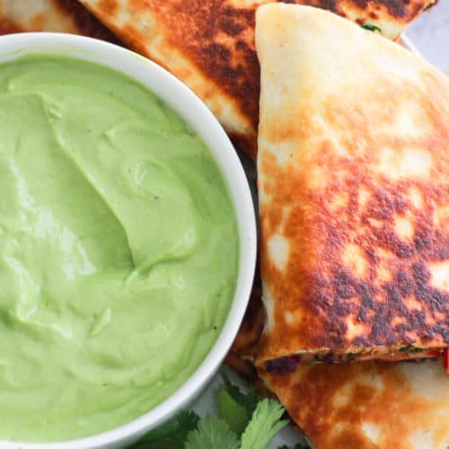 Overhead image of vegetarian quesadilla with avocado crema.