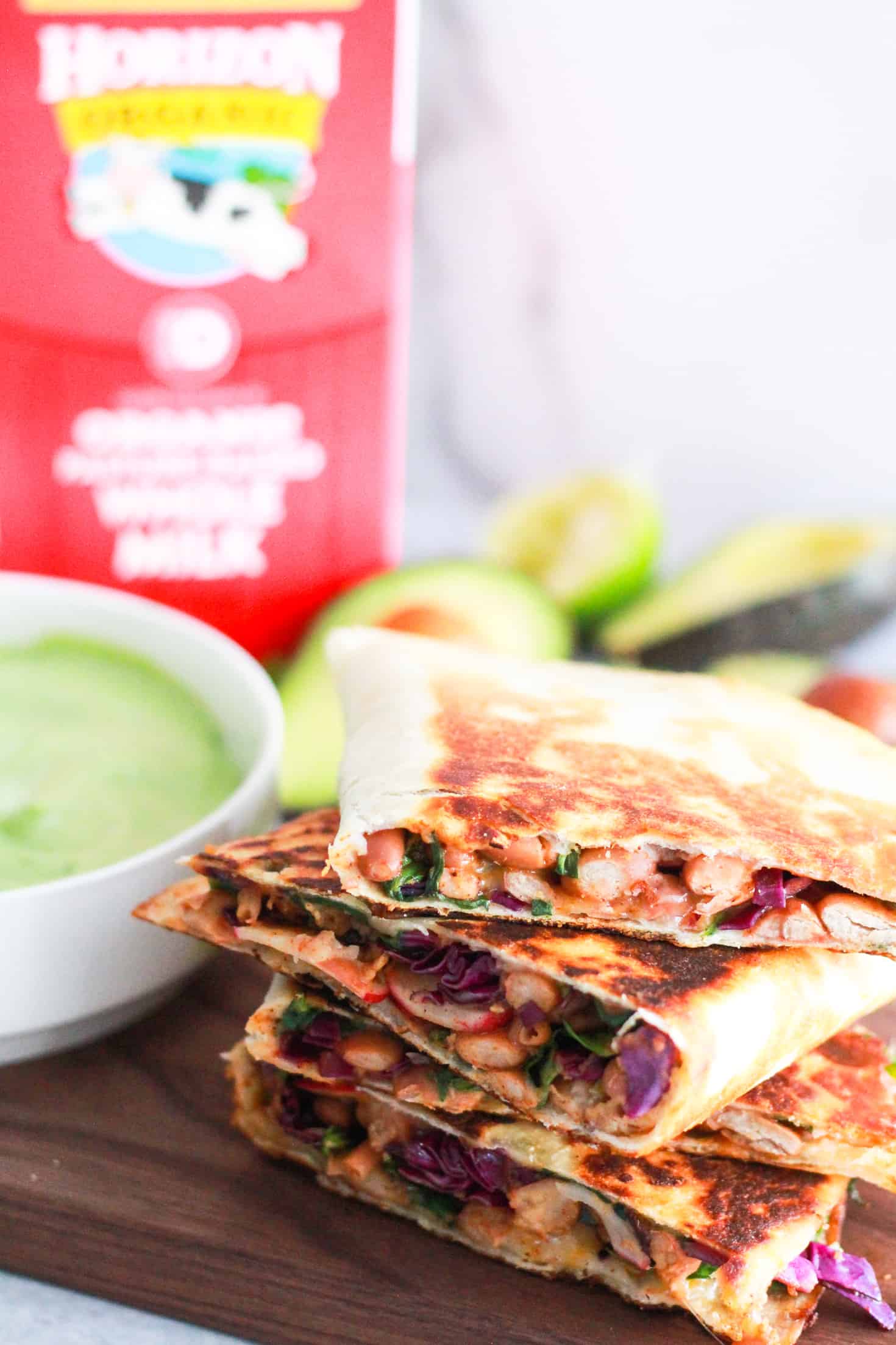 Pinto Bean Quesadillas on wood board with avocado crema.