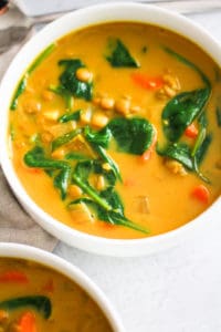 lentils and spinach in a bowl of stew.