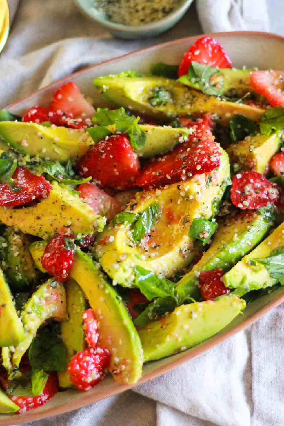 Closeup of Strawberry Avocado Salad on beige platter.